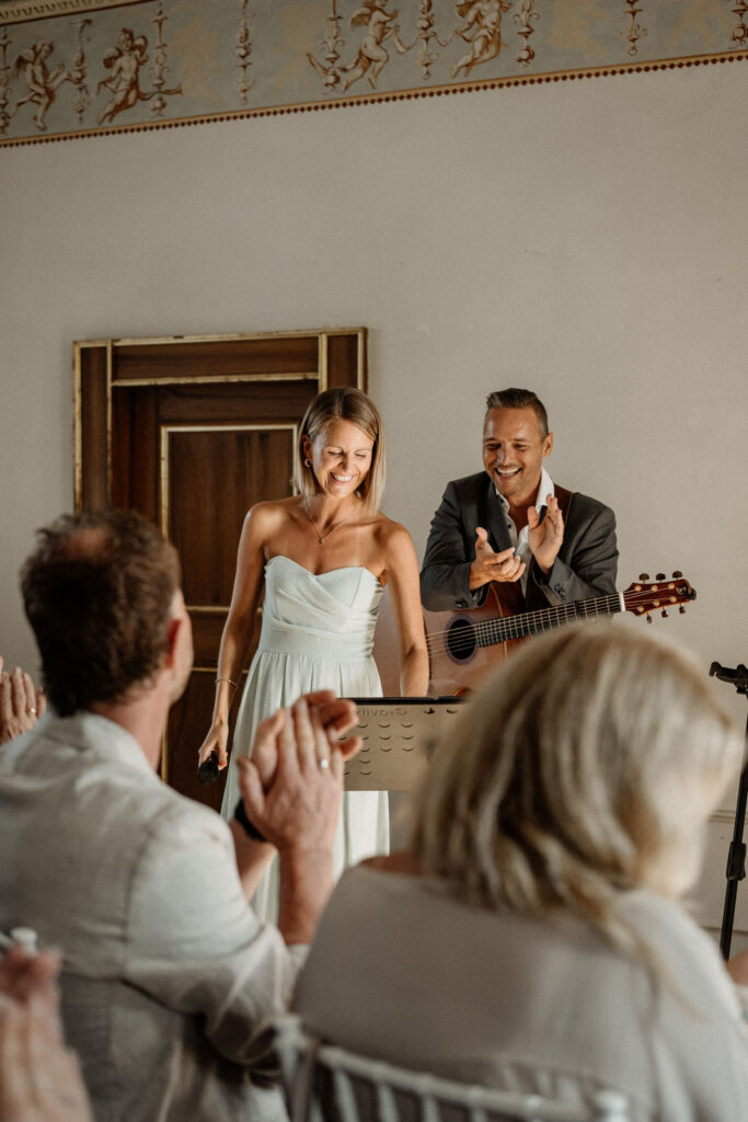 Hochzeitsmusiker begleiten eine freie Trauung mit Gesang und Gitarre im Innenraum