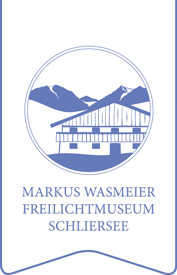Logo eines Gebäudes im Chalet-Stil mit Bergen und dem Schriftzug „Markus Wasmeier Freilichtmuseum Schliersee“.